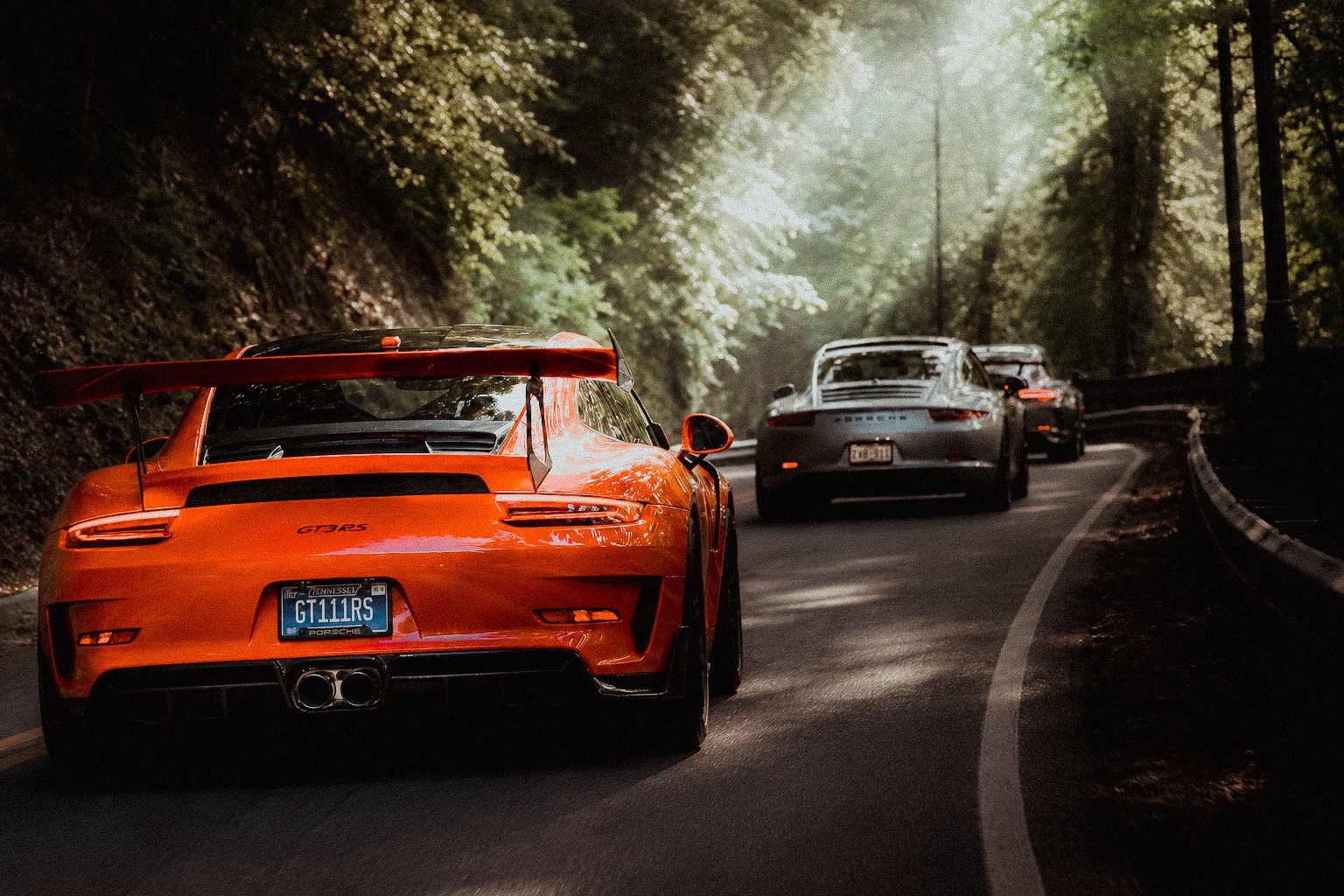 Orange Porsche on a mountain road